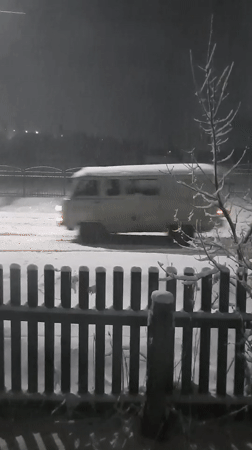 White van drives through heavy snowfall in Krasnogorskoye