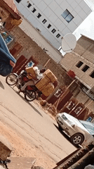 Motorcyclist carries cardboard boxes through Maiburiji street