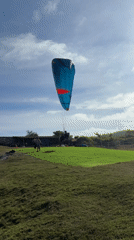 Paragliders soar over Kuta Selatan coast under clear skies