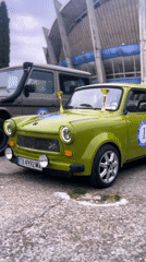 Trophy-adorned cars gather in parking lot, engine inspection observed