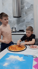 Two boys make homemade pizza in Chaikovsky kitchen