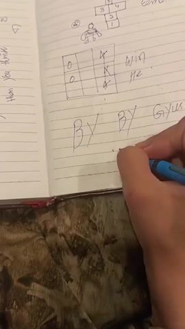 A person's hand is writing in a notebook. The notebook is open to a lined page. On the page there are several drawings. At the top of the page is a hopscotch grid with numbers 1 through 6. Below the hopscotch grid is a tic-tac-toe board with "0" in the top left and bottom left squares, and "X" in the top middle and middle right squares. Next to the tic-tac-toe board are the words "win me." Below this are the words "BY BY Giyus" with a handwritten "love you" underneath. The person's hand is holding a blue pen and is in the process of writing the word "you." The background of the image shows a textured surface, possibly a table.
