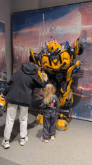 Child poses with Bumblebee robot display in Kamyshin