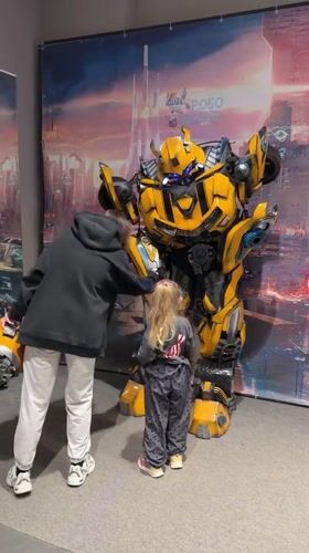 Child poses with Bumblebee robot display in Kamyshin