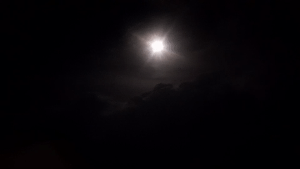Moonlight breaking through clouds over Abuja at night