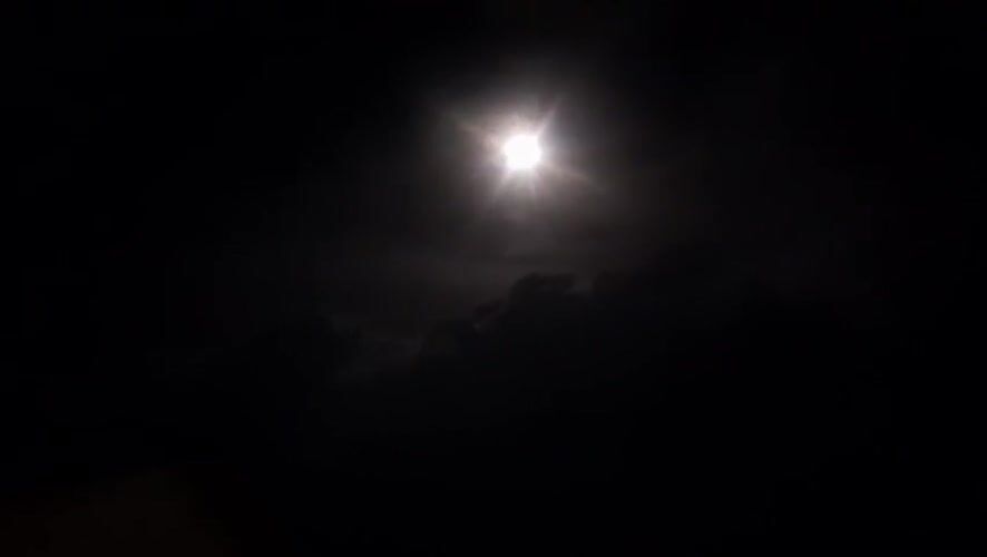 Moonlight breaking through clouds over Abuja at night