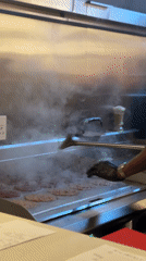 Cook prepares smash burgers at Cape Town restaurant kitchen