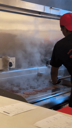 Cook prepares smash burgers at Cape Town restaurant kitchen