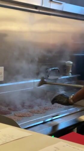 Cook prepares smash burgers at Cape Town restaurant kitchen