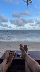 Two people rest feet on table in Mũi Né