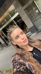 Woman takes selfies outside Berlin building wearing leopard print