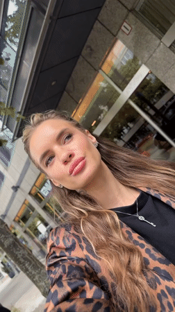 Woman takes selfies outside Berlin building wearing leopard print