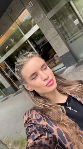 Woman takes selfies outside Berlin building wearing leopard print