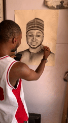 Man studies wall portrait while holding smartphone