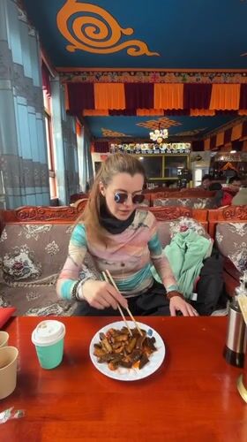 Woman dines at ornate Tibetan restaurant in Jila, China