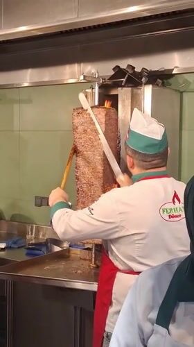 Chef slices meat from rotisserie grill in Vienna