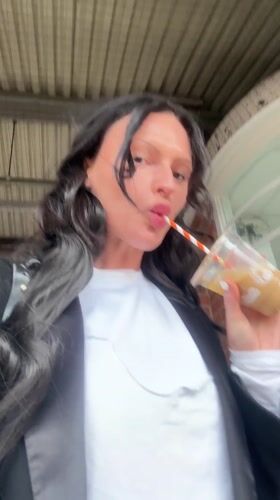 Woman drinks iced coffee at Tonbridge train station