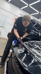 Man applies protective film to Toyota in Krasnoyarsk garage