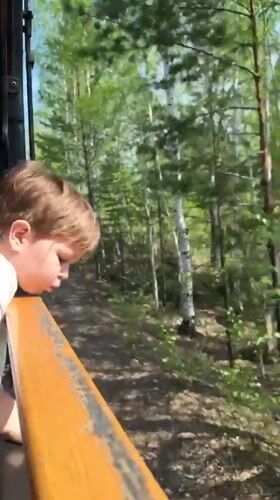 Child rides morning train through Russian town, watches scenery