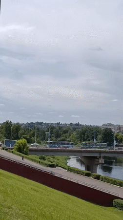 Vitsebsk riverfront, amusement park, and city monument on a June morning