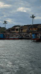 Traditional boats navigate Hội An waterways under overcast skies