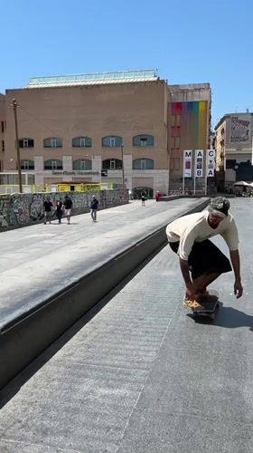 Skaters session a sunny Barcelona plaza on a June morning