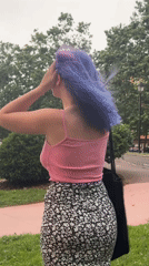 Woman with colorful hair explores parks, plants in Gijón