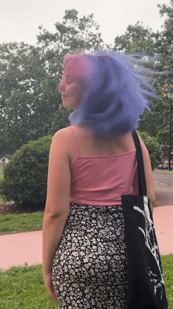 Woman with colorful hair explores parks, plants in Gijón