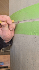 Worker chips concrete from marked column in Herzliya