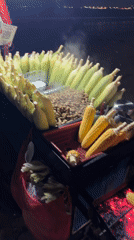 Street vendor grills corn in Kuta Selatan night market