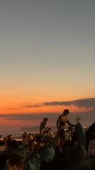 Kuta Beach at golden hour — crowds, dogs, and sunset light