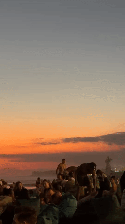 Kuta Beach at golden hour — crowds, dogs, and sunset light