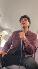 Man sings into microphone aboard train in Sitges