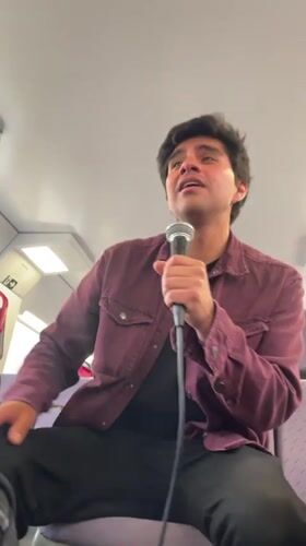 Man sings into microphone aboard train in Sitges