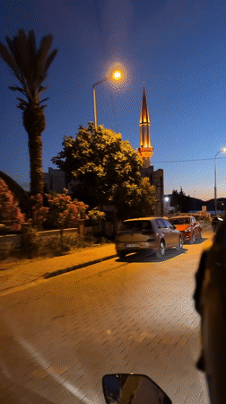 Nighttime street scene captured near illuminated mosque construction in Fethiye
