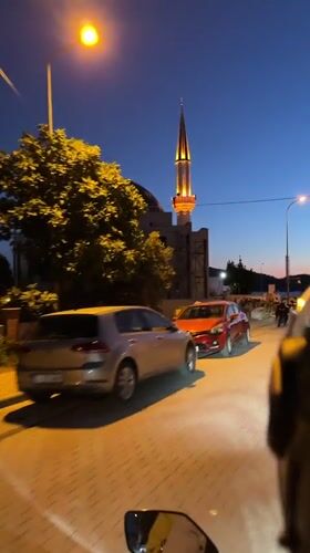 Nighttime street scene captured near illuminated mosque construction in Fethiye