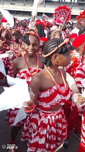 Children in green-white costumes gather on Lagos street