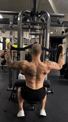 Tattooed man works out at early morning gym session