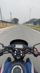 Motorcyclist rides blue Honda on empty Panchkhola road