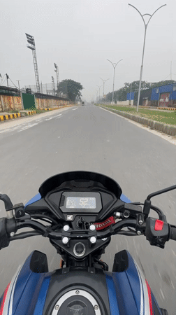 Motorcyclist rides blue Honda on empty Panchkhola road