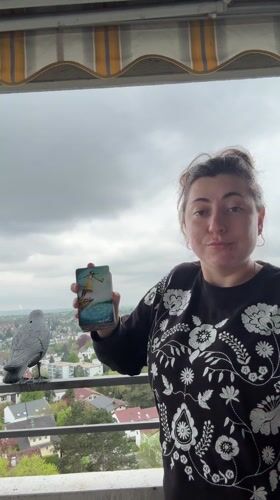 Woman displays tarot cards on balcony in Waiblingen