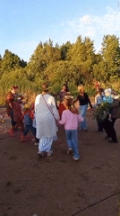 Outdoor celebration with circle dancing and flower crowns