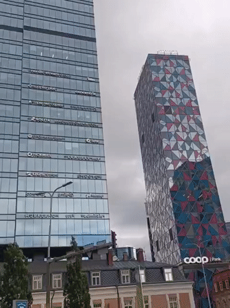 Tallinn business district: glass towers, public art, and robed cross-bearers
