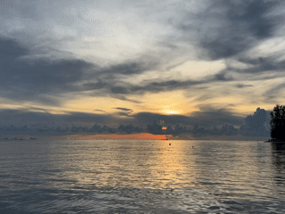 Golden sunset captured through clouds at Thai coastal village