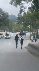 Two riders use electric scooters on Sochi road