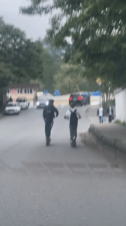 Two riders use electric scooters on Sochi road