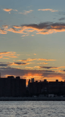Sunset captured over New York waterway and skyline
