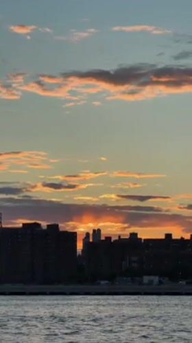 Sunset captured over New York waterway and skyline