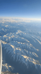 Aerial view captures snow-covered mountains from aircraft window