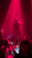 Nightclub performance and DJ set under red neon lights